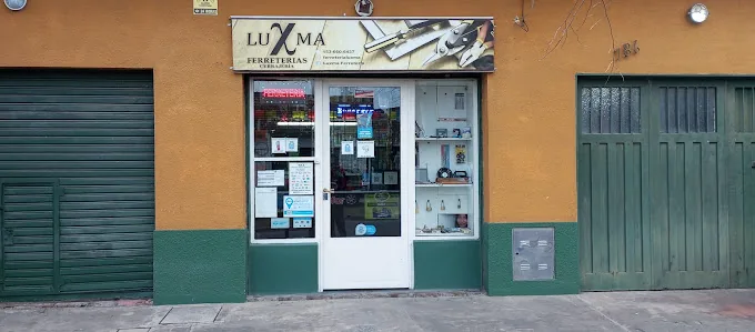 Frente de Luxma con el zócalo verde, al lado del portón